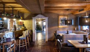 un restaurante con bar, mesas y sillas en Hotel Bellavista, en Alpe di Siusi
