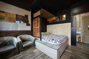 馬公市的住宿－傻風旅店，一间卧室配有一张床和两把椅子