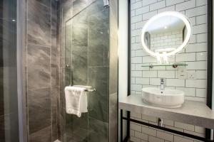 a bathroom with a sink and a mirror at Santa Grand Signature Kuala Lumpur in Kuala Lumpur