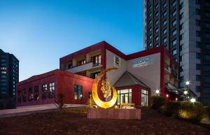 een gebouw met een groot gouden bord ervoor bij Edelweiss Art Hotel in Ulaanbaatar