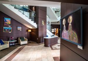 eine Lobby mit einem großen Gemälde einer Frau an der Wand in der Unterkunft Edelweiss Art Hotel in Ulaanbaatar