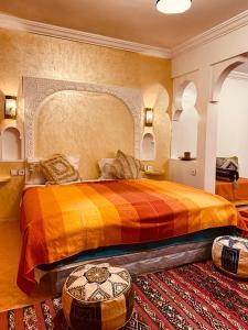 a bedroom with a large bed with a colorful bedspread at Auberge Tissadrine in Akhendachou nʼAït Ouffi