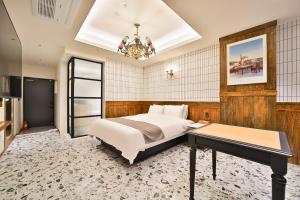 Daegu February Hotel Lions Park في دايغو: غرفة نوم بسرير وطاولة وثريا