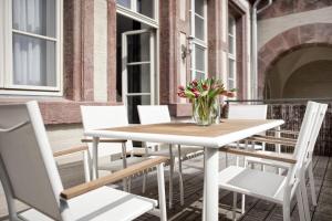 a table and chairs on a balcony with a vase of flowers at Studio 44 in Leipzig