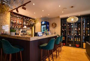 eine Bar mit grünen Stühlen in einem Raum in der Unterkunft Edelweiss Art Hotel in Ulaanbaatar