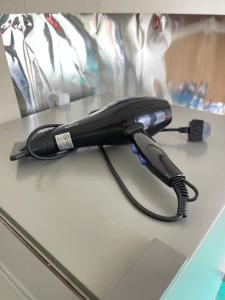 a black hair dryer sitting on top of a counter at Pelangi Capsule Hostel in Johor Bahru