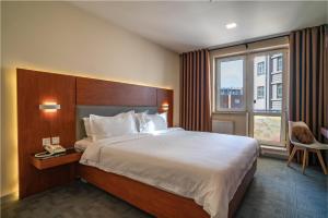 a hotel room with a large bed and a window at Edelweiss Art Hotel in Ulaanbaatar