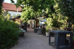 un jardín con mesas, sillas y un árbol en Heimat Floral Ferienhaus, en Wadgassen