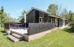 een zwart huis met een terras in de tuin bij 3 Bedroom Stunning Home In Sams in Onsbjerg