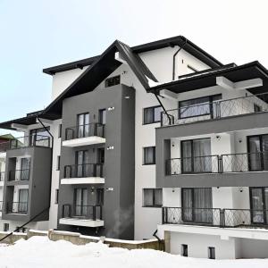 un condominio con neve di fronte di R&B Studio a Predeal