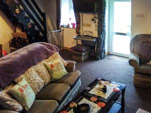 sala de estar con sofá y mesa de centro en Ty Newydd Green Cottage, en Llanfachraeth