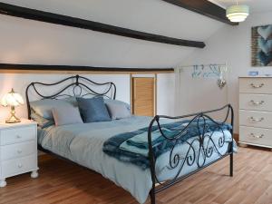 1 dormitorio con 1 cama grande y vestidor blanco en Ty Newydd Green Cottage, en Llanfachraeth