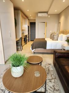 - un salon avec un lit, un canapé et des tables dans l'établissement Zimbali Lakes Boulevard Suites, Unit148, à Ballito