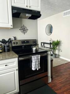 a kitchen with a stove with a tea kettle on it at The Traveler's Retreat, 5 mins to airport and 15 mins to downtown in Atlanta
