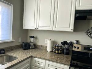 a kitchen with white cabinets and a counter top at The Traveler's Retreat, 5 mins to airport and 15 mins to downtown in Atlanta