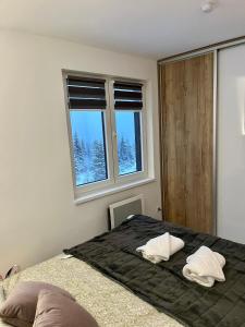 a bedroom with a bed with two white pillows on it at Pinewood apartment Jahorina in Jahorina