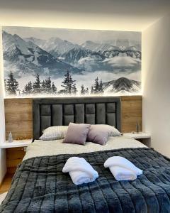 a bedroom with a large bed with two pillows at Pinewood apartment Jahorina in Jahorina