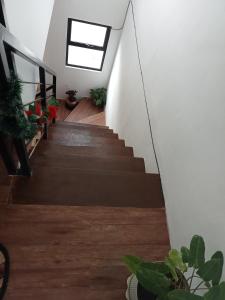 una escalera en una casa con suelo de madera y ventana en Phirst Park Homes Townhouse en Lipa