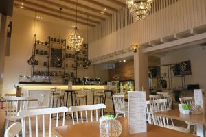 a restaurant with white chairs and tables and a bar at Kallisti Apartments in Skiathos