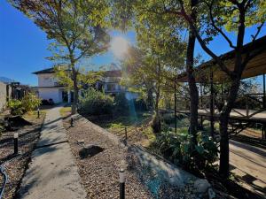 a garden with trees and a house in the background at Little Bir in Bīr