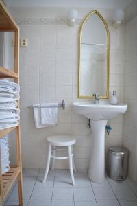 a bathroom with a sink and a mirror and a stool at Family Apartment Písek City Centre II. in Písek