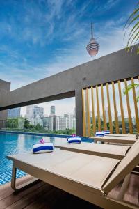 a pool with a table and chairs next to the water at Santa Grand Signature Kuala Lumpur in Kuala Lumpur