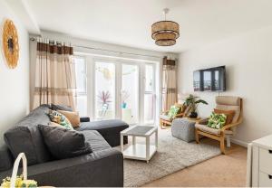 a living room with a gray couch and chairs at White House in Bournemouth