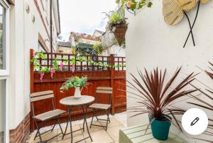 a small balcony with a table and chairs and flowers at White House in Bournemouth