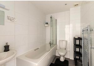 a bathroom with a tub and a toilet and a sink at White House in Bournemouth +13 photos