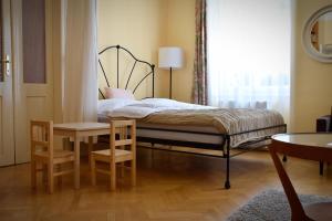 a bedroom with a bed and a table and chairs at Family Apartment Písek City Centre II. in Písek