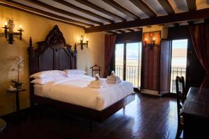 a bedroom with a large bed and a balcony at El Retiro del Obispo in Laguardia