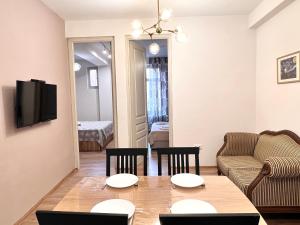 - un salon avec une table, des chaises et un canapé dans l'établissement leselidze apartament, à Tbilissi
