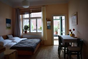 a bedroom with a bed and a table and a window at Family Apartment Písek City Centre II. in Písek