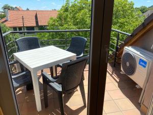 a balcony with a table and chairs on a balcony at Bella Apartman in Balatonfüred