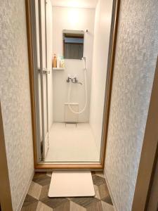 a mirror in a bathroom with a shower at Otaru Garden Stay in Otaru
