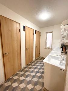 ein Badezimmer mit einem Waschbecken und einer Arbeitsplatte in der Unterkunft Otaru Garden Stay in Otaru