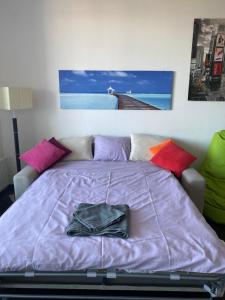 1 dormitorio con 1 cama grande de color púrpura con almohadas coloridas en Fantastic view from the 20th floor en Bratislava