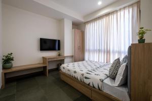 a bedroom with a bed and a flat screen tv at C'est La Vie Boutique Apartments by Le Pension Stays in Jaipur