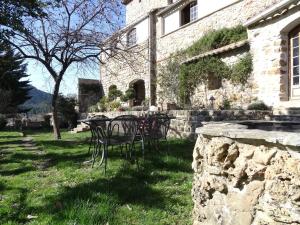 een tafel en stoelen voor een gebouw bij Le Mas du Galibot Gîte Barulaïre in Saint-Florent-sur-Auzonnet