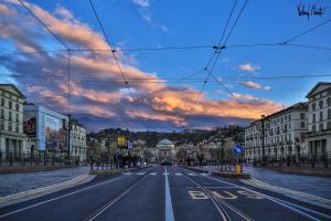 an empty street in a city with a cloudy sky at Albergo in Centro in Turin