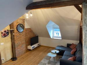 a living room with a couch and a tv at Charmandy in Cany-Barville