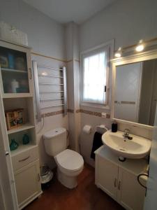 ein weißes Bad mit einem WC und einem Waschbecken in der Unterkunft Somnis Menorca in Arenal d'en Castell