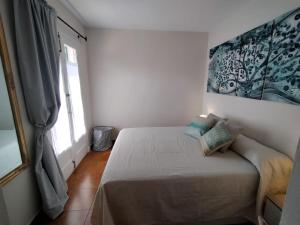 ein Schlafzimmer mit einem Bett in einem Zimmer mit einem Fenster in der Unterkunft Somnis Menorca in Arenal d'en Castell