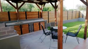 eine Terrasse mit einem Tisch und Stühlen sowie eine Küche in der Unterkunft Villa Rêve in Nea Kallikratia