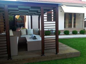 eine Pergola mit einem Sofa und einem Tisch im Hof in der Unterkunft Villa Rêve in Nea Kallikratia