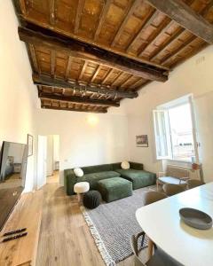 a living room with a green couch and a table at Aphrodite Apartment Piazza Venezia in Rome