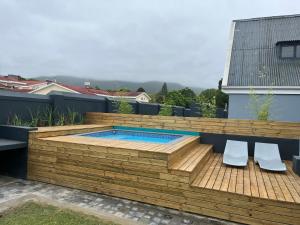 a deck with a swimming pool and two chairs at 28 on Symonds Luxstudio 4 with solar backup in George