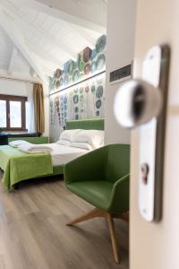 a bedroom with a bed and a green chair at Hotel Lago Di Garda in Malcesine +92 photos