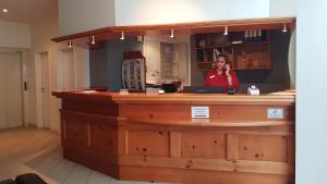 a woman talking on a cell phone behind a counter at Weinhotel Römerbad in Bad Salzuflen