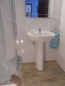 a bathroom with a white sink and a mirror at Apartamento Neptuno in Benagil +28 photos